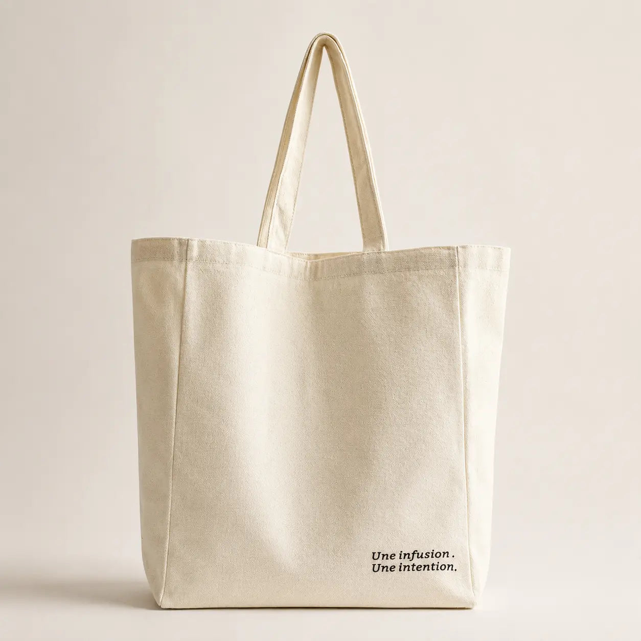 Tote bag en coton écru, format spacieux 33 × 34 × 10 cm, avec longues anses pour un porté épaule.