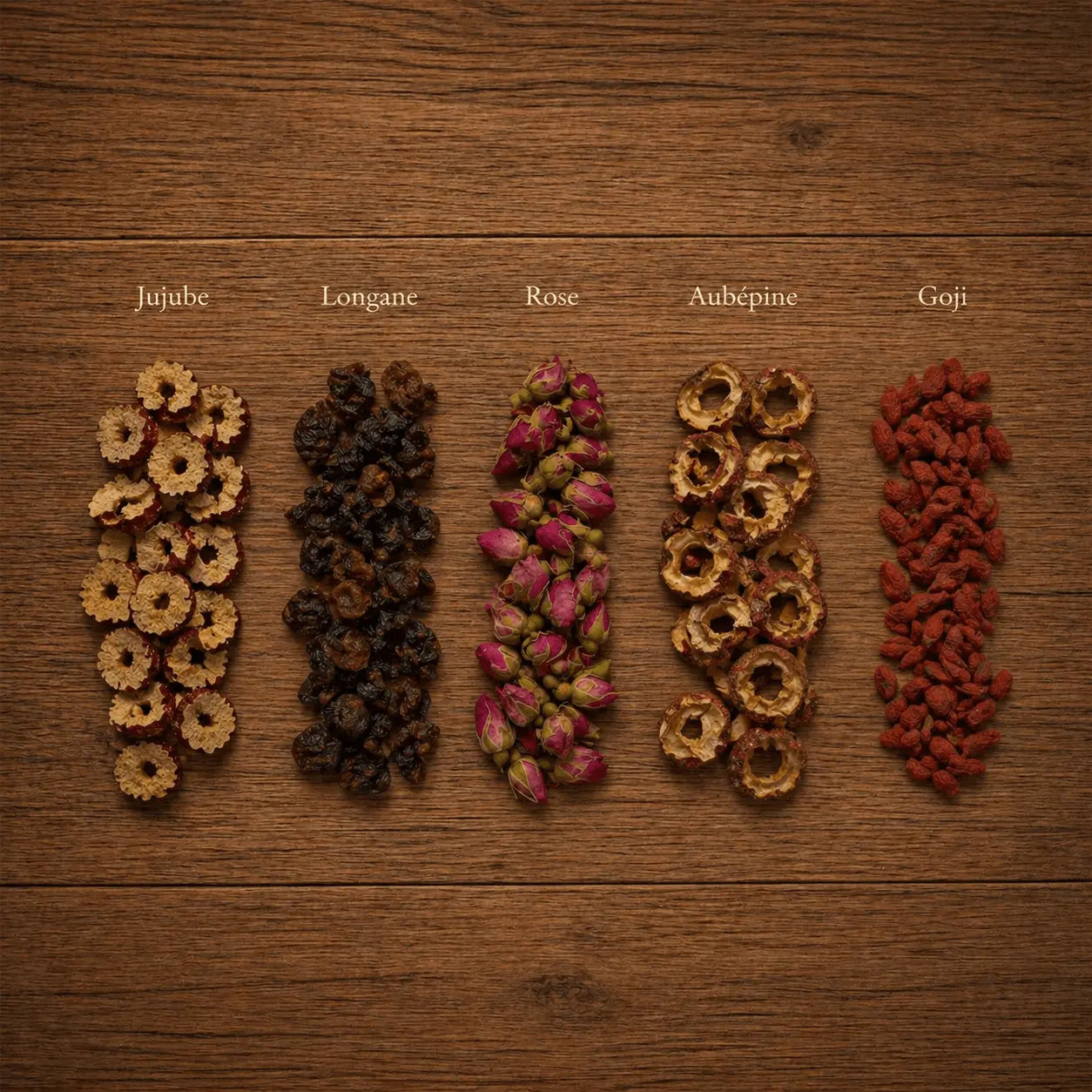Cinq ingrédients de l'infusion cycle féminin N°28 THÉCHA : jujube, longane, boutons de rose, aubépine et goji, disposés sur un fond en bois naturel